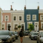 A person walking down a street lined with parked cars