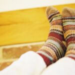 Striped woollen socks against a wooden beam and brick wall